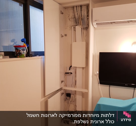 ארון פתוח עם חוטי חשמל וצינורות חשופים